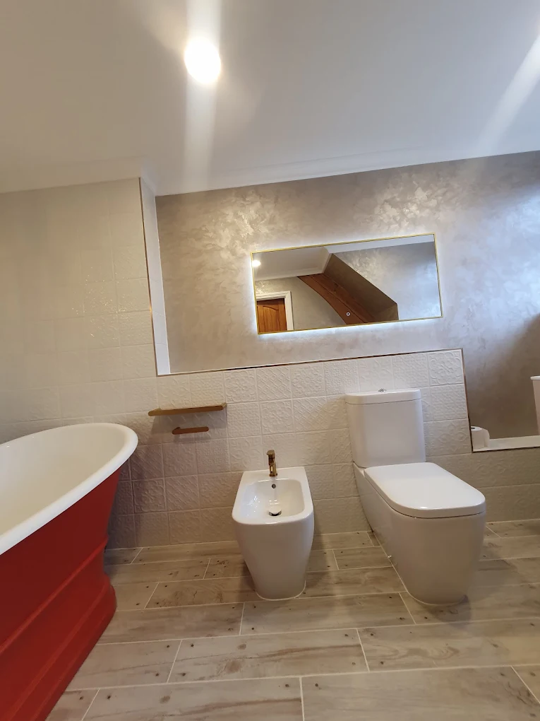 Modern bathroom with red freestanding bath renovated by CIN Construction